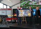 Kirchner mit weiteren Personen halten Fotoleinwand auf Bühne