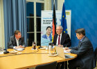 Besprechungssituation, Innenminister Joachim Herrmann und Frau Dr. Jung im Gespräch mit den zugeschalteten Teilnehmerinnen und Teilnehmern