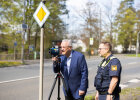 Herrmann blickt durch Messgerät, neben ihm ein Polizist