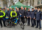 Gruppenfoto mit Innenminister Joachim Herrmann, Polizisten in Uniformen und in gelben Neon-Fahrradwesten, im Vordergrund Polizeifahrrad