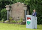 Kirchner am Rednerpult neben Kriegsgräberdenkmal