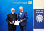 Innenminister Joachim Herrmann und Dr. Bernhard Haßlberger mit Medaille und Urkunde