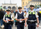 3 Polizistinnen und Polizisten auf Festival, im Hintergrund Festivalbesucher