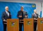 Herrmann, Söder und Ströhlein vor Pressewand bei Pressekonferenz