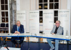 Herrmann neben weiterer Person an Tisch sitzend