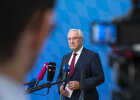 Innenminister Joachim Herrmann vor Mikrofonen bei Pressekonferenz