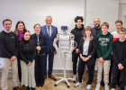 Gruppenfoto mit Schülerinnen, Schülern, Lehrerinnen und Lehrern, in der Mitte Roboter "pib" und Joachim Herrmann