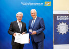 Innenminister Joachim Herrmann und Jürgen Wanat mit Medaille und Urkunde