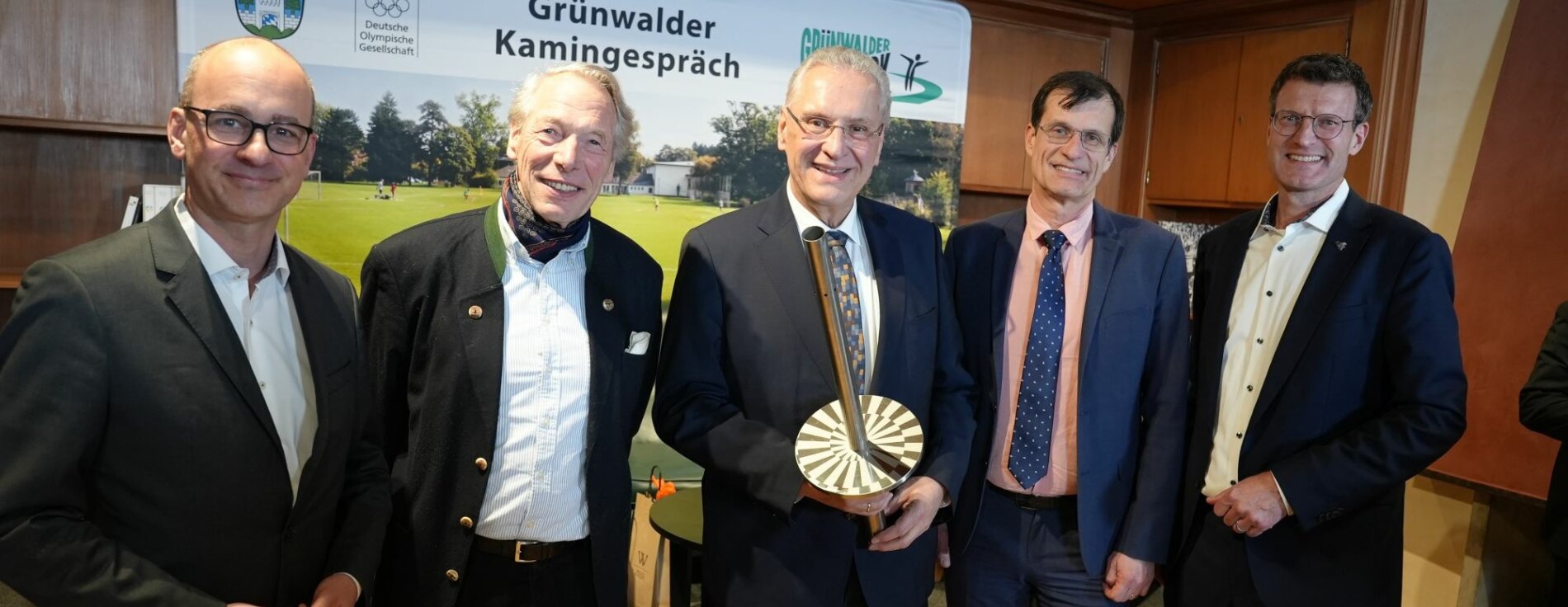 27. Februar 2025: „Unser Ziel ist ganz klar: Die Olympischen und Paralympischen Spiele sollen wieder nach Bayern kommen!.“ Das sagte Bayerns Innen- und Sportminister Joachim Herrmann beim 7. Grünwalder Kamingespräch, das der Chefredakteur des Bayerischen Fernsehens, Christian Nitsche, moderiert hat. Auf dem Foto sind die Teilnehmer des Grünwalder Kamingesprächs zu sehen, in der Mitte Innenminister Joachim Herrmann, der die Olympische Fackel von den Spielen 1972 in den Händen hält.