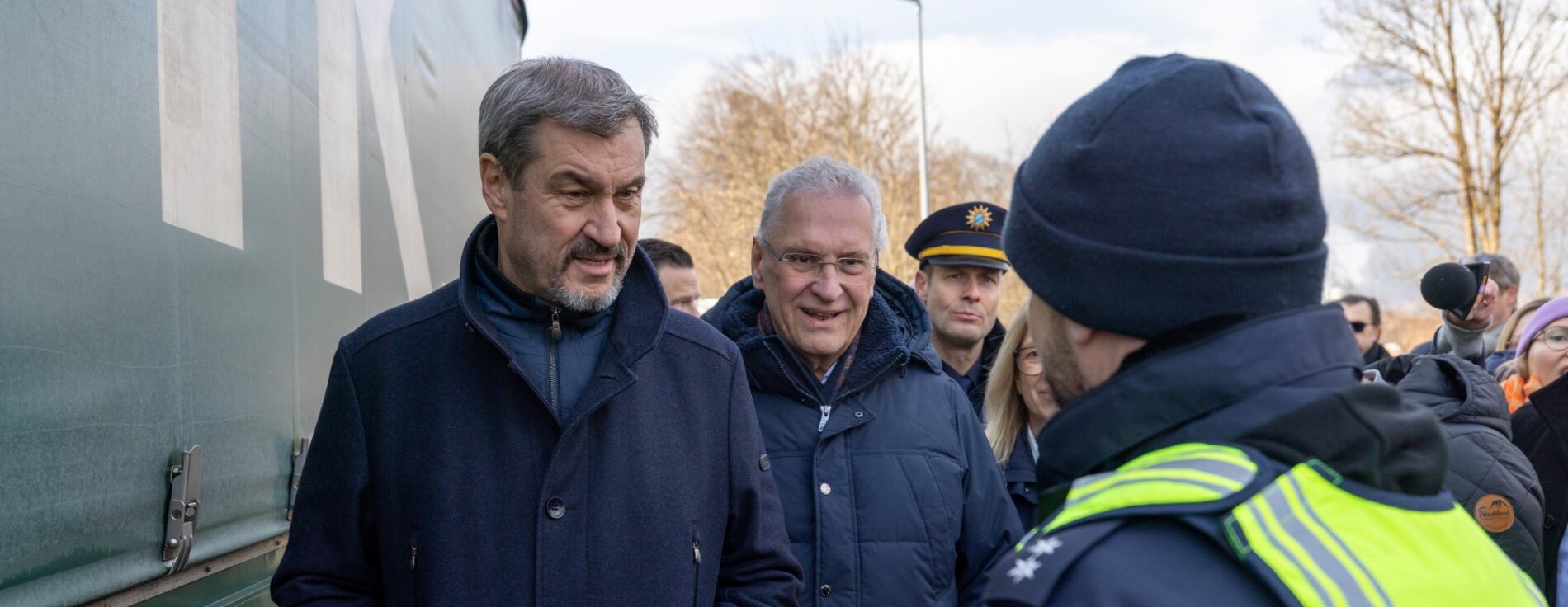 6. Februar 2025: „Die Arbeit unserer Grenzpolizei ist wichtiger denn je!“ Bayerns Ministerpräsident Dr. Markus Söder und Innenminister Joachim Herrmann haben am Grenzübergang Oberaudorf an der deutsch-österreichischen Grenze die Jahresbilanz 2024 der Bayerischen Grenzpolizei festgestellt. Herrmann: „Zwar konnten wir im letzten Jahr deutliche Rückgänge erzielen. Aber nachdem die Zahl der unerlaubten Einreisen und Schleuserdelikte im Jahr 2023 so hoch wie nie seit der Gründung der Bayerischen Grenzpolizei war, gibt es keine Entwarnung." Auf dem Bild sind Ministerpräsident Dr. Markus Söder und Innenminister Joachim Herrmann gemeinsam mit einem Polizisten der Bayerischen Grenzpolizei zu sehen.