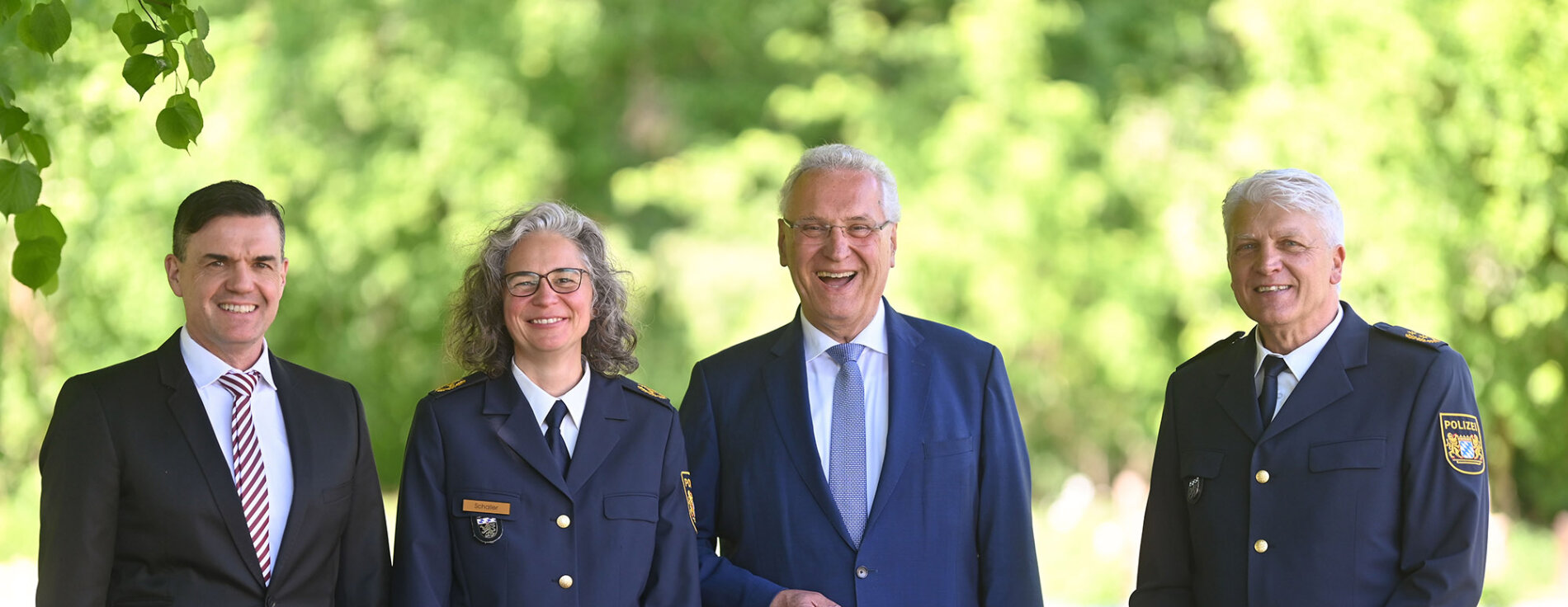 Feierlicher Moment des Übergangs: Innenminister Joachim Herrmann verabschiedet Günther Gietl in den Ruhestand und begrüßt Kerstin Schaller als neue Polizeipräsidentin von Oberbayern Nord – Dirk Schmidt wird ihr Stellvertreter. Gruppenbild (von links nach rechts:) Dirk Schmidt, neuer Polizeivizepräsident PP Oberbayern Nord, Kerstin Schaller, neue Polizeipräsidentin PP Oberbayern Nord, Innenminister Joachim Herrmann, Günther Gietl Polizeipräsident Oberbayern Nord a.D. im Hintergrund grüne Bäume