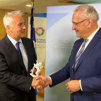 Innenminister Joachim Herrmann schüttelt Makis Voridis die Hand, dieser hält ein Geschenk
