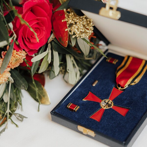 Bundesverdienstkreuz in Schachtel und Blumenstrauß