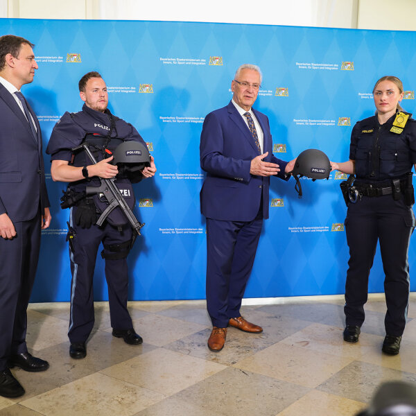 Herrmann und Eisenreich präsentieren mit zwei Polizeibeamten die Schutzausrüstung