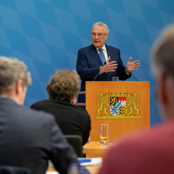 Innenminister Joachim Herrmann hinter Rednerpult bei Pressekonferenz