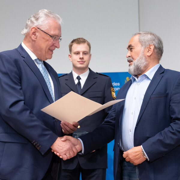 Herrmann überreicht einem Geehrten eine Urkunde