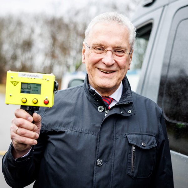 Herrmann mit gelbem elektronischen Gerät in der Hand