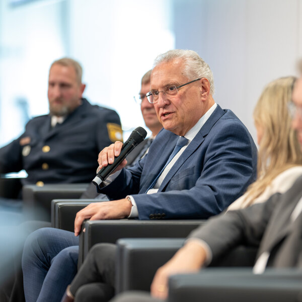 Herrmann mit Mikrophon bei Diskussion