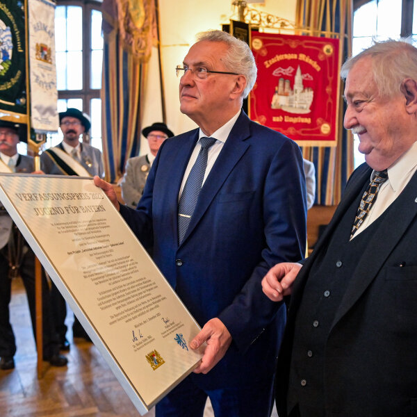 Herrmann mit Bilderrahmen Verfassungspreis in der Hand, daneben älterer Herr