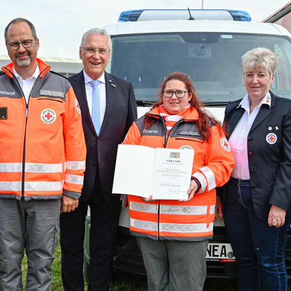 Gruppenfoto vor neuem Fahrzeug: Einsatzkräfte des BRK, Innenminister Herrmann und BRK-Präsidentin Angelika Schorer