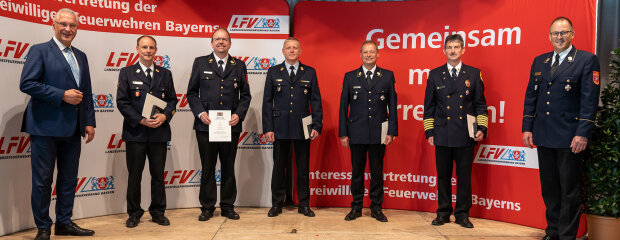 Steckkreuz für besondere Verdienste um das Feuerwehrwesen Gruppenfoto der geehrten Feuerwehrleuten mit Steckkreuz und Urkunde
