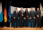 Gruppenbild stehend auf der Bühne neben Fahnenset von links nach rechts: Manfred Hauser, neuer Präsident des Landesamts für Verfassungsschutz (LfV), Innenminister Joachim Herrmann, Landtagspräsidentin Ilse Aigner, Frank Hellwig, neuer Polizeipräsident PP Oberbayern Süd, Michael Siefener neuer Polizeivizepräsident PP Oberbayern Süd