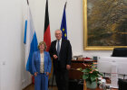 Generalkonsulin Lador-Fresher und Innenminister Herrmann im Ministerbüro vor Fahenenset