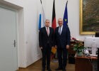 Innenminister Herrmann und der rumänische Innenminister Catalin Prediou vor Fahnenset im Büro von Innenminister Herrmann in München