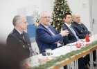 Minister Herrmann sitzend im Gespräch mit Polizistinnen und Polizisten