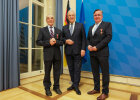 Minister Herrmann mit Herrn Johann (Hans) Reichart und Dr. Michael Bayeff-Filoff vor einem Fahnenset