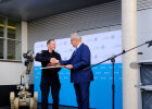 Staatsminister Herrmann mit Hr. Link beim Überreichen Geschenk auf der Bühne
