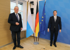 Innenminister Joachim Herrmann und Generalkonsul von Griechenland neben Fahnen