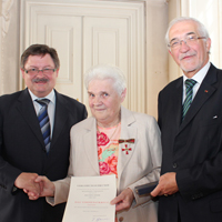 Staatssekretär Gerhard Eck (links) händigt Verdienstorden an Rosa Winter aus