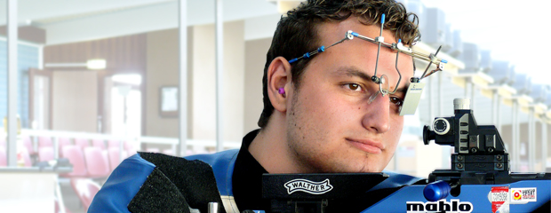 Sportschütze auf einem Schießstand Auf einem Schießstand justiert ein Sportschütze seine Waffe und setzt zum nächsten Schuss an