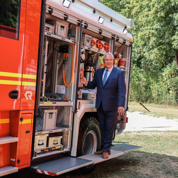 Herrmann neben offenem Feuerwehreinsatzfahrzeug