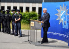 Innenminister Joachim Herrmann hinter Rednerpult neben Bereitschaftspolizei 