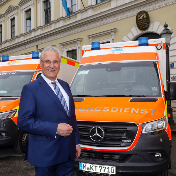 Innenminister Joachim Herrmann vor Rettungsdienst-Fahrzeugen vor dem Innenministerium