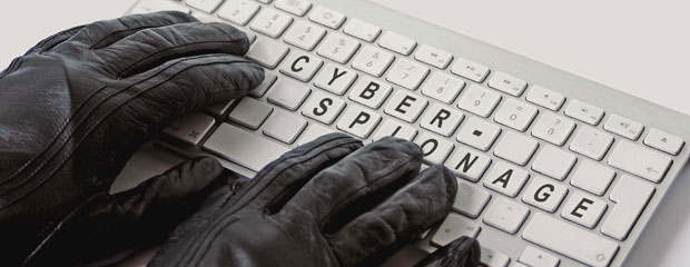Ein Computer wird ausspioniert. Handschuhe an einer Tastatur: Schriftzug "Cyberspionage"