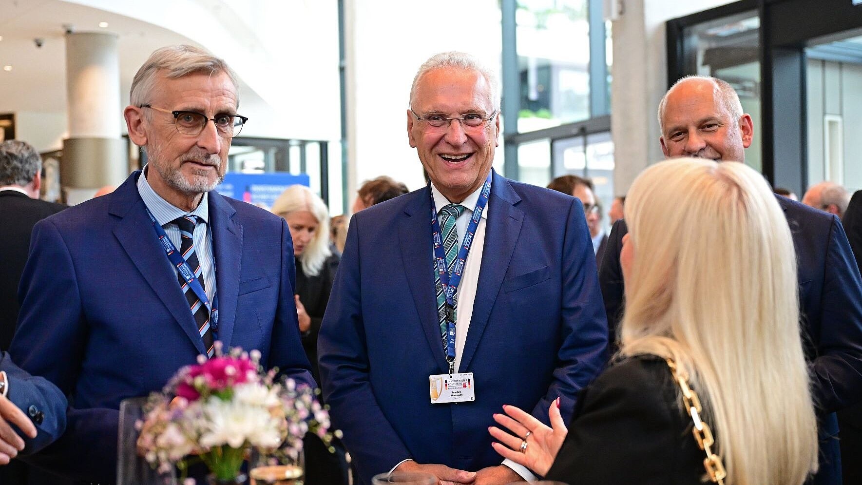 Mehrere Personen unterhalten sich lächelnd in einem Foyer des Congresszentrums Hamburg.