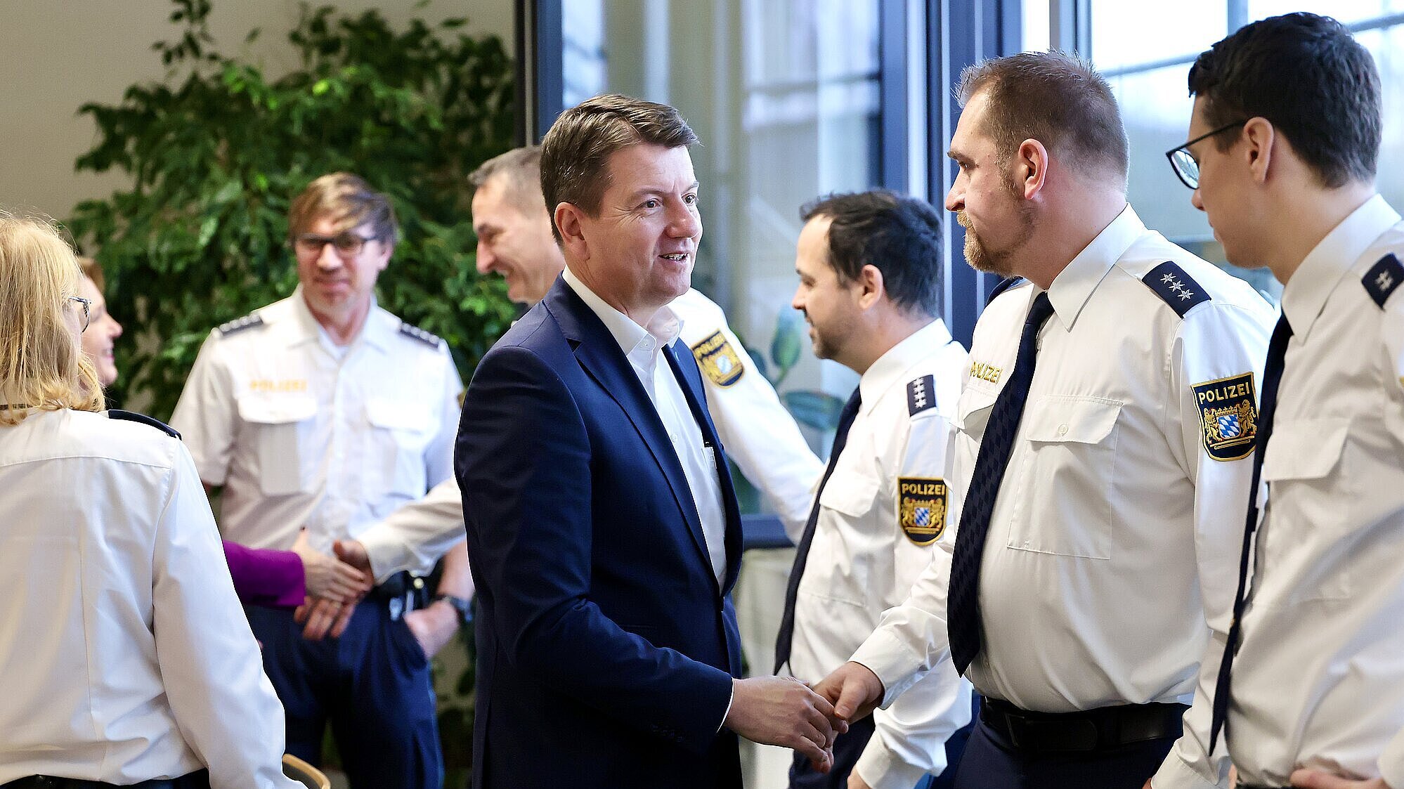 Innenstaatssekretär Sandro Kirchner schüttelt Polizistinnen und Polizisten die Hand.