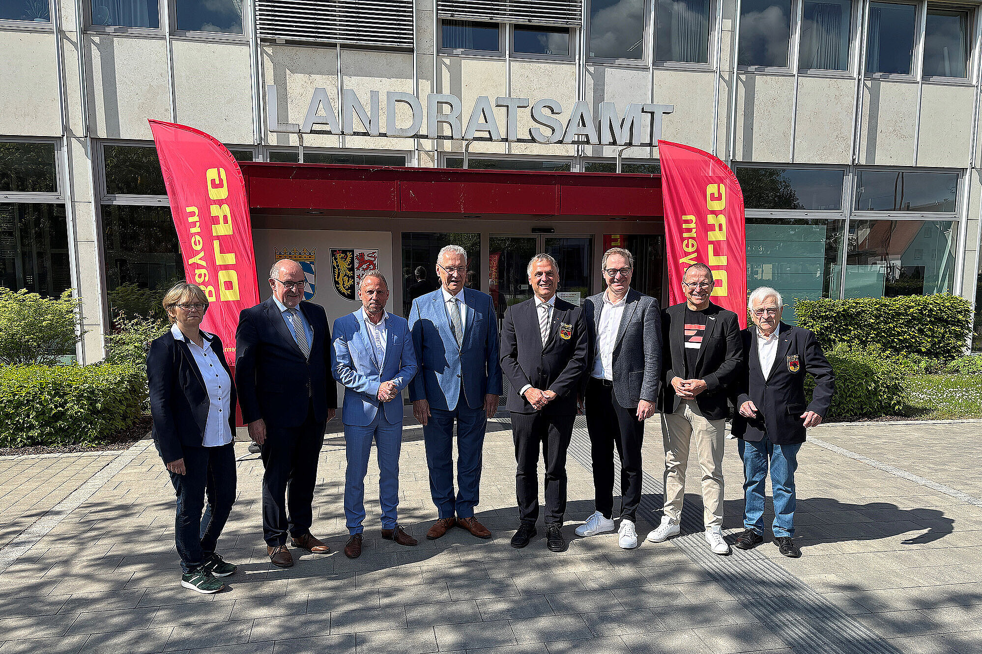 Gruppenbild mit dem Vorstand der DLRG in der Mitte steht Innenminister Herrmann, links neben ihm Umweltminister Torsten Glauber vor dem Landratsamt Neumarkt