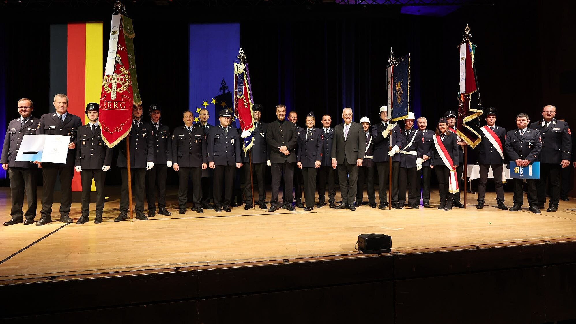 Ministerpräsident Dr. Markus Söder und Innenminister Joachim Herrmann anlässlich des Staatsempfangs mit vielen Feuerwehr-Vertreterinnen und Vertretern auf der Bühne.