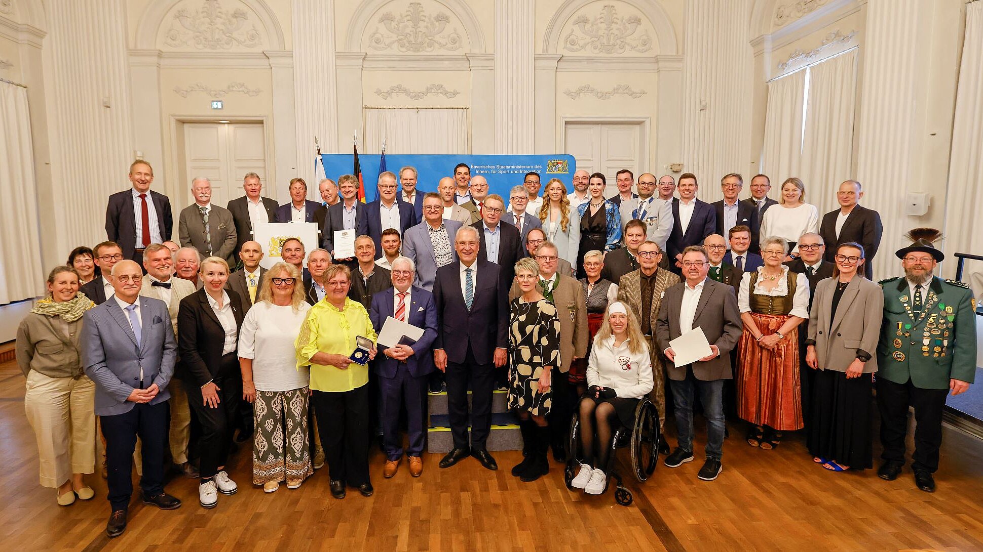 Auf dem Bild sind alle Geehrten mit Herrn Staatsminister vor der historischen Kulisse in der Residenz München zu sehen.