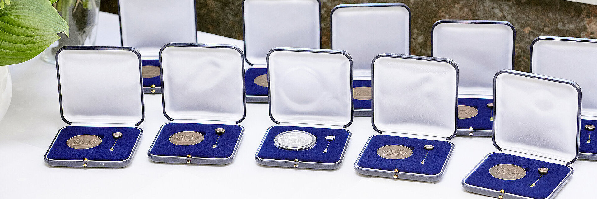 Mehrere Kommunale Verdienstmedaillien in Bronze und Silber im Etui aufgereiht auf einem Tisch