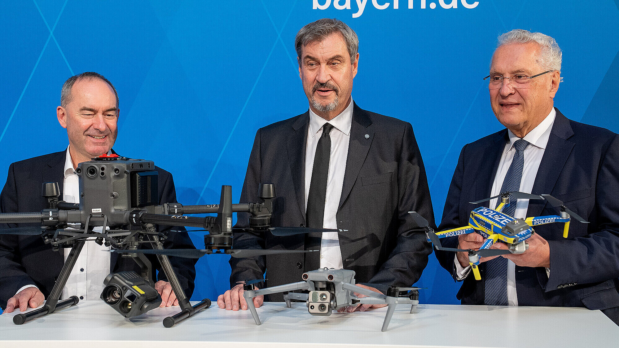 Ministerpräsident Dr. Markus Söder, Wirtschaftsminister Hubert Aiwanger und Innenminister Joachim Herrmann vor Pressewand mit Drohnen