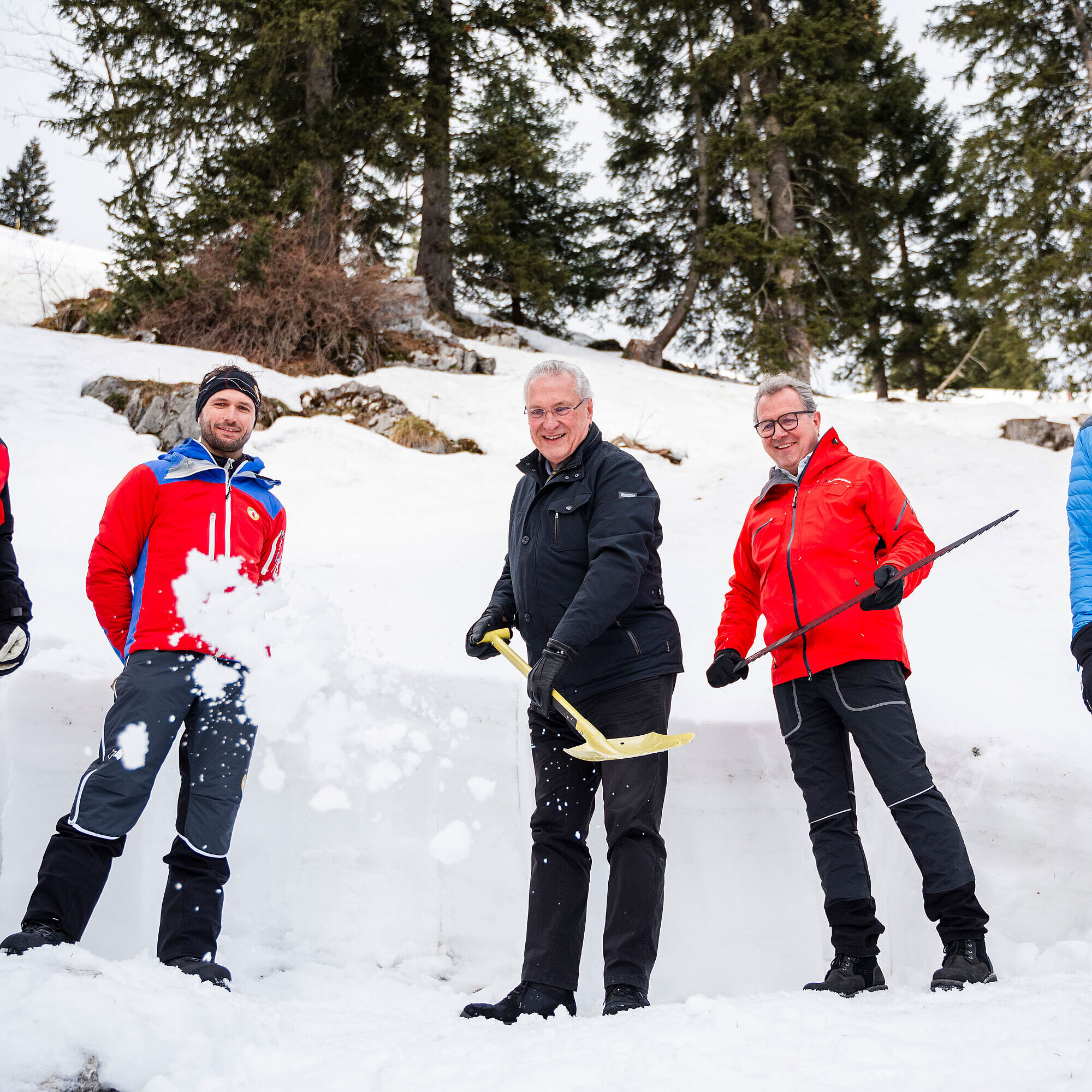 Herrmann und Stöttner  mit Einsatzkräften und Lawinenschaufeln im Schnee