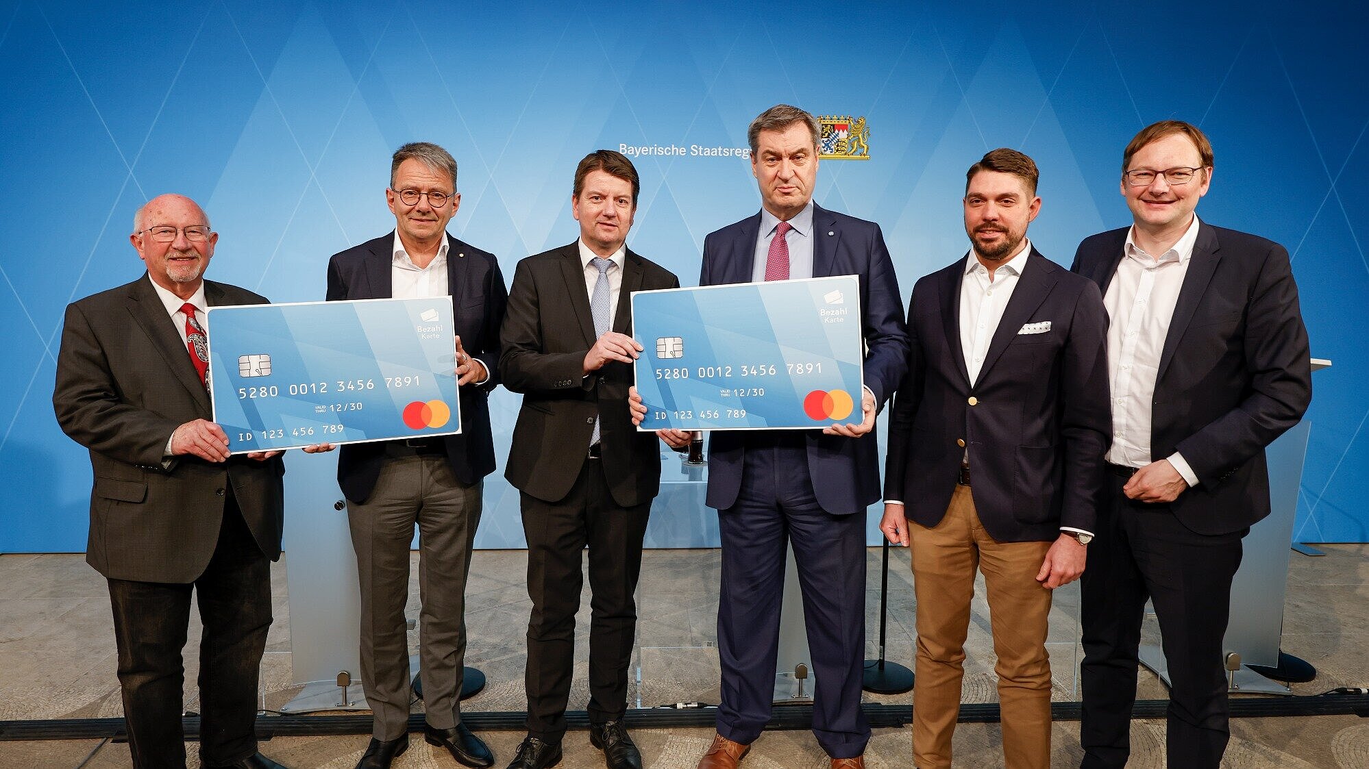 Söder, Kirchner und Karmasin und weitere mit großen Bezahlkarte-Schildern