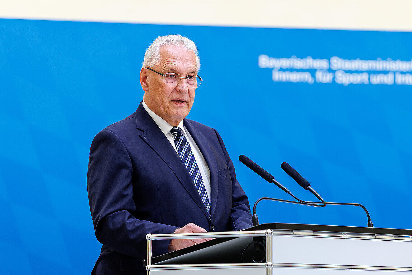 Innenminister Joachim Herrmann am Rednerpult vor Pressewand