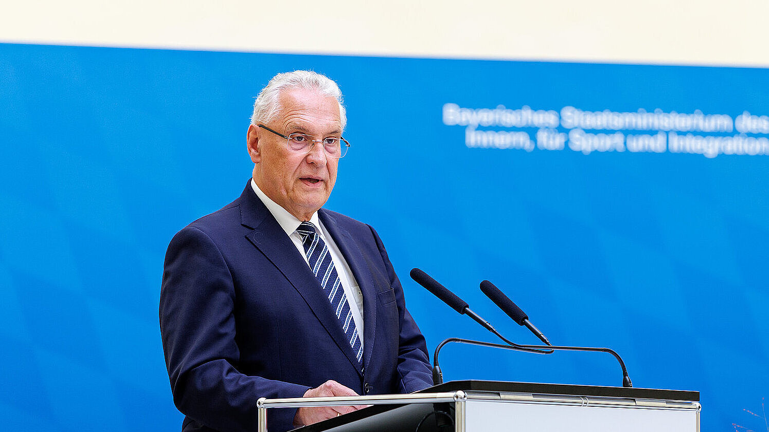 Innenminister Joachim Herrmann am Rednerpult vor Pressewand