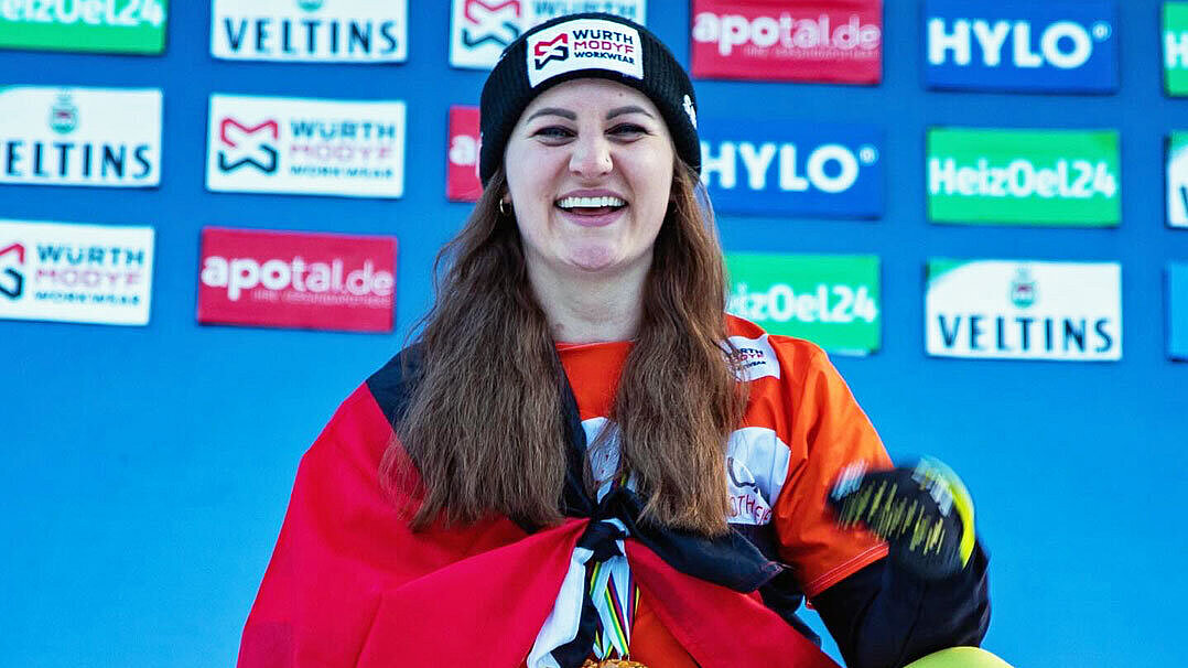 Hofmeister steht hinter ihren drei Kristallkugeln. Um die Schultern hat sie die Deutsche Fahne gelegt.